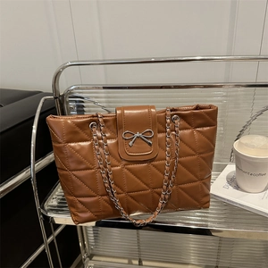 Brown quilted tote bag with silver bow detail and chain strap for stylish office commute
