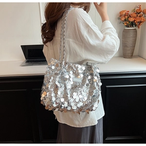 Detailed view of silver sequin tote bag featuring woven strap and fashion label detail