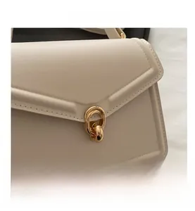 Detailed close-up of textured PU leather and elegant interlocking gold metal buckle