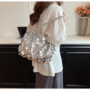 Silver sequin tote bag with woven shoulder strap shown in a stylish indoor setting