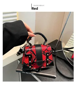 Detail of red snake pattern texture and gold rivets on this stylish square handbag