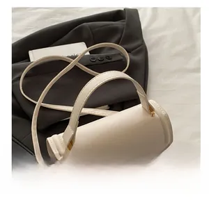 Detail of white leather handbag with golden twist lock and elegant top handle design