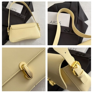 Detail of cream-colored leather underarm bag featuring gold hardware and fine stitching
