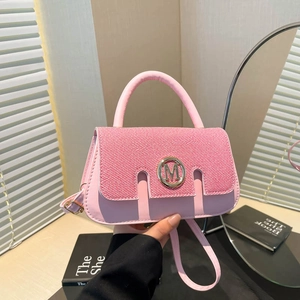 Pink fashion handbag with M logo metal buckle and leather strap in lifestyle setting