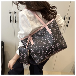 Close-up of printed shoulder tote bag featuring pink ribbons and heart pattern detail