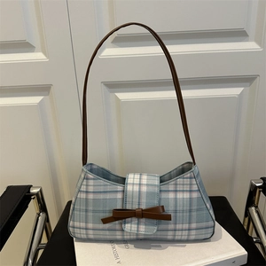 Chic tricolor striped underarm bag with a brown leather bow on a minimalist background