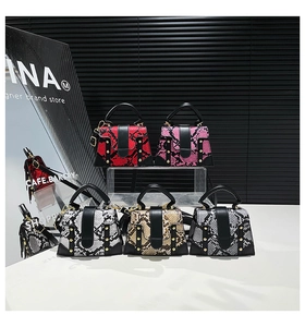 Detail of five mini handbags featuring textured snakeskin patterns and elegant gold studs