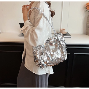 Close-up of silver sequin tote bag with metallic texture and woven shoulder strap