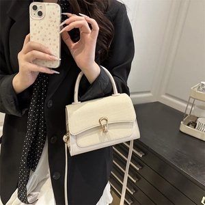Elegant cream contrast leather crossbody bag with weave texture and gold horseshoe clasp