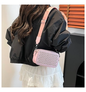 Détail du sac bandoulière rose à strass avec large sangle porté par un mannequin