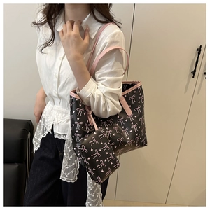 Vue détaillée du sac cabas noir avec imprimés nœuds roses et une pochette assortie