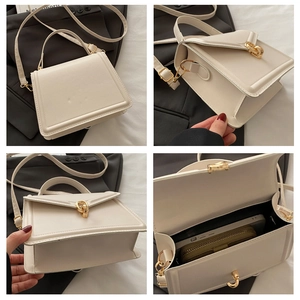 Detail view of cream leather handbag showing gold clasp and internal storage capacity