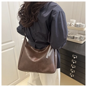 Detailed back view of a brown vintage hobo bag with white lace ribbon accessory