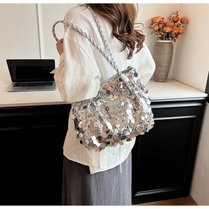 Detailed view of silver sequin tote bag with woven shoulder strap on female model