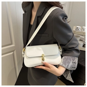 Minimalist white underarm bag with gold lock closure on a grey suit-wearing model