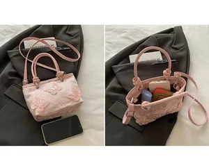 Détail du sac seau brodé rose montrant le compartiment principal intérieur spacieux