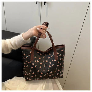 Gros plan du sac cabas vintage à imprimé cerise avec anses en cuir marron