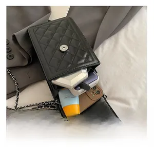Detail view of the black quilted crossbody bag showing interior capacity for a smartphone