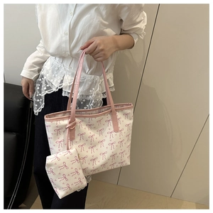 Detail of the bow print tote bag set featuring a matching small pouch on a shoulder strap