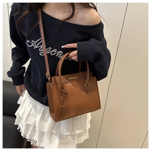 Detail of brown litchi pattern tote bag featuring gold Fashion & Bags lettering