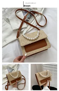 Detail of woven straw handbag with brown leather trim and elegant pearl top handle