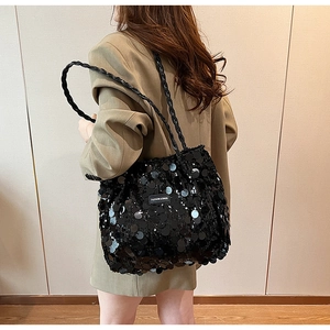 Detail of black sequin tote bag showing the braided shoulder strap and shiny texture