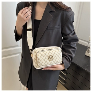 Macro shot of beige vintage monogram crossbody bag with golden M logo and wide strap