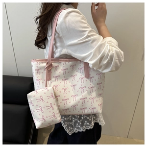 Sac fourre-tout tendance avec motifs de nœuds roses porté par un mannequin en salle