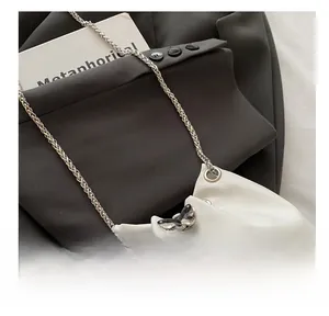 Close-up of crocodile texture leather bucket bag with silver chain and butterfly clasp