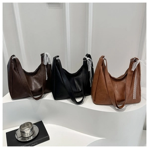 Detailed close-up of soft faux leather hobo bags featuring lace bow accents in three colors