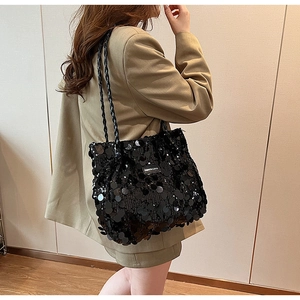 Detail of black sequin tote bag with woven straps and Fashion & Bags metal logo tag