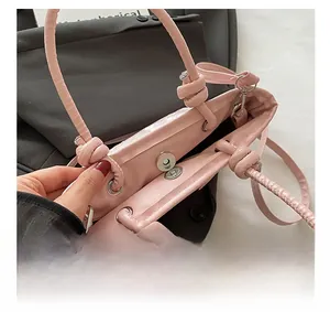 Vue détaillée du sac seau rose avec fermeture magnétique et bandoulière nouée