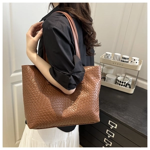 Close-up of the brown woven leather texture and grid pattern on the large tote bag
