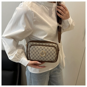 Detail of vintage crossbody bag showing dual zipper pockets and gold metal M logo charm