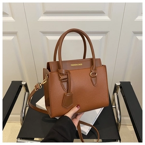 Close-up of brown litchi pattern leather bag with golden FASHION & BAGS text