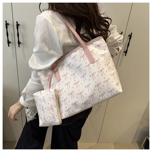 Détail du grand sac cabas blanc à nœuds roses avec sa pochette assortie portée à l'épaule