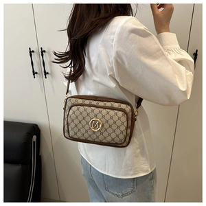 Detail of vintage crossbody bag featuring brown monogram pattern and golden M logo hardware