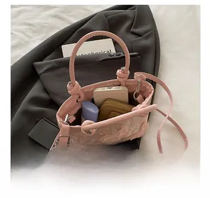 Détail montrant la grande capacité du sac seau rose brodé de dentelle et de papillons
