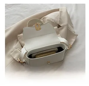 Interior capacity display of cream leather crossbody bag with smartphone and wallet inside