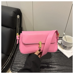 Detailed view of pink leather underarm bag featuring a gold metal buckle and wide strap