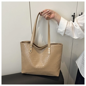 Detailed shot of large woven tote bag with silver rivets and elegant texture
