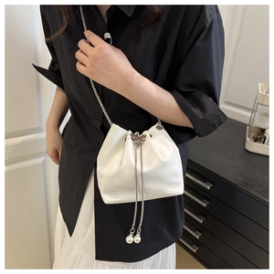 Detailed view of crocodile texture bucket bag with butterfly clasp and pearl drawstring