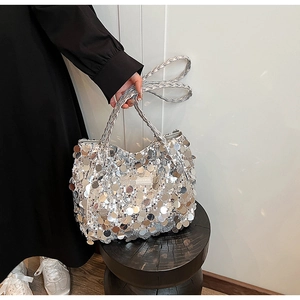 Detailed view of silver sequin tote bag with woven handles and fashion logo tag