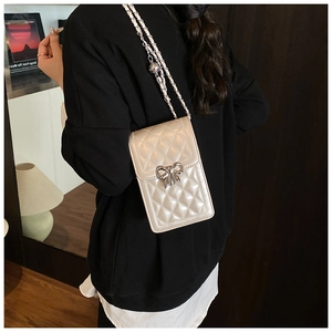Close-up of quilted pattern phone bag with silver bow buckle and metal ball chain