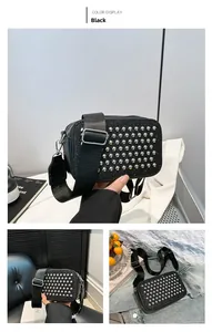 Detail of black rectangular crossbody bag with silver studs and wide nylon strap