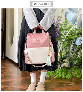 Pink and cream nylon backpack detail featuring a cute Rabbit patch and colorful tassel charm