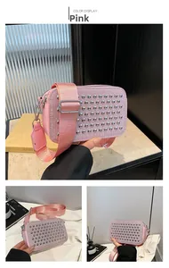 Detail of pink camera bag featuring silver dome studs and a wide adjustable nylon strap