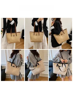 Detail view of woven straw tote bags in beige and light brown showing model styling