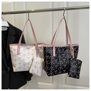 Detail of printed tote bag set with pink bows and matching zipper pouch on a hanger