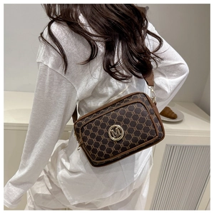 Detailed view of vintage monogram crossbody bag with golden M logo and wide fabric strap